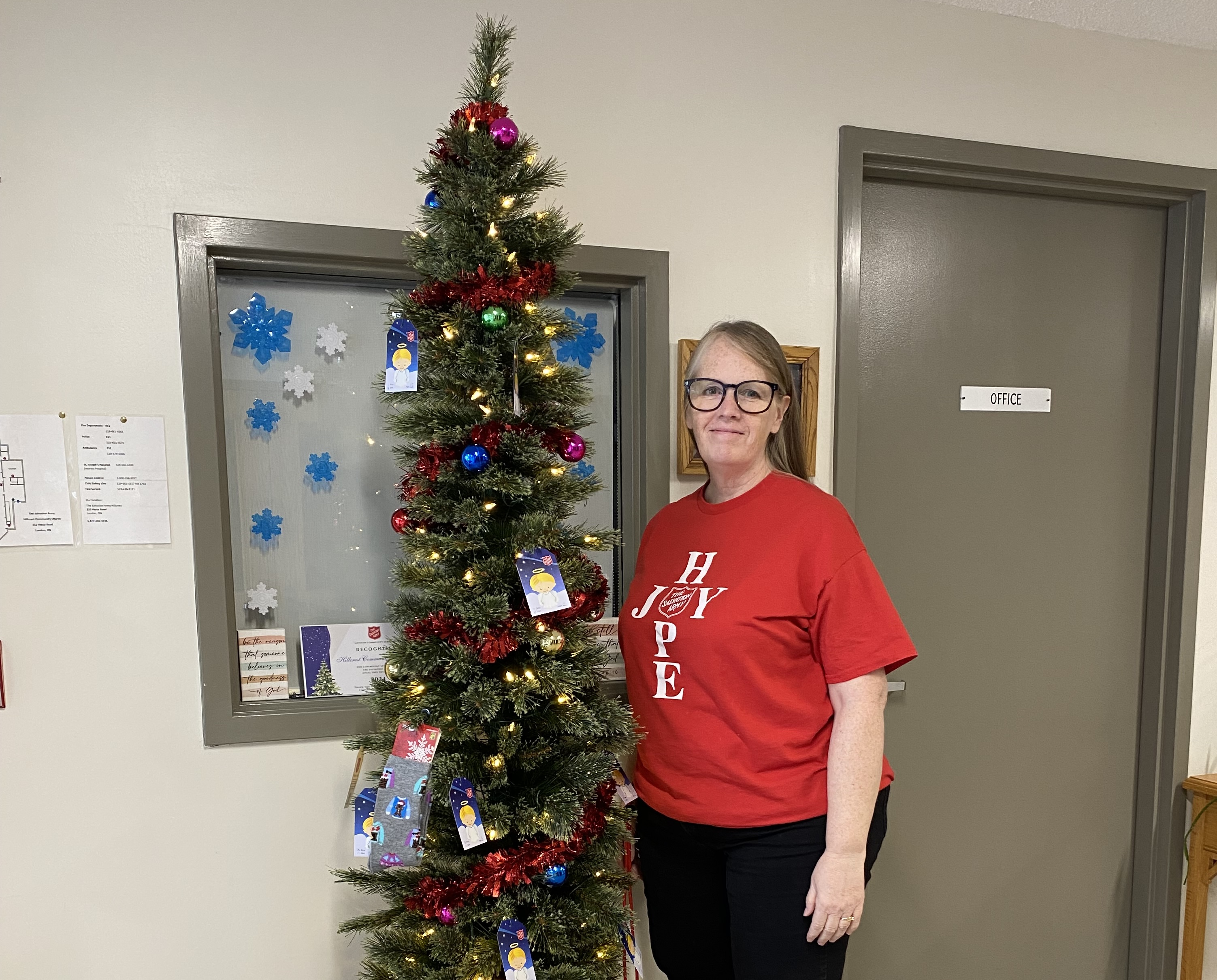 Salvation Army worker stands by Christmas tree